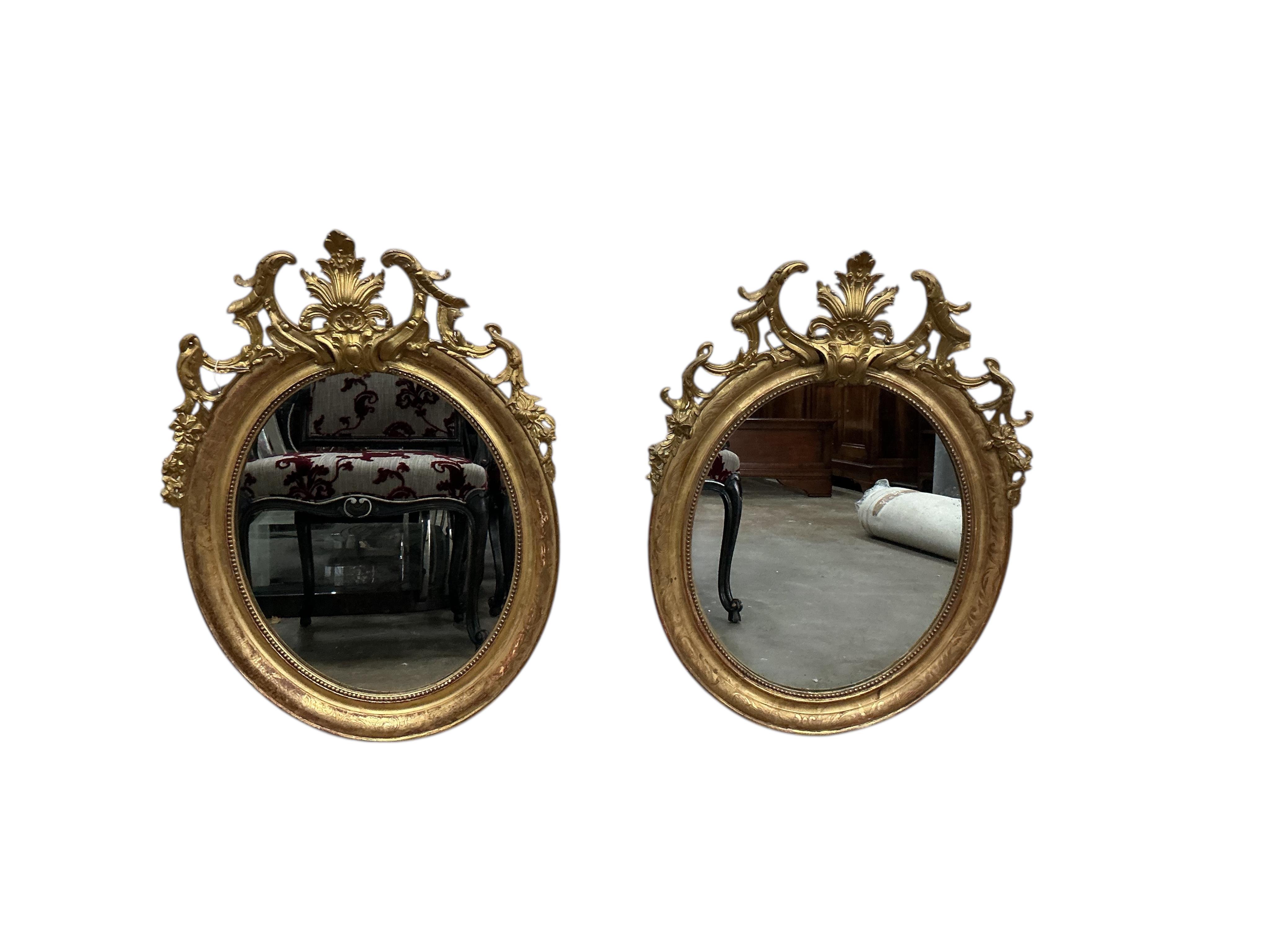 A pair of 19th century French giltwood and composition oval wall mirrors, width 68cm, height 91cm